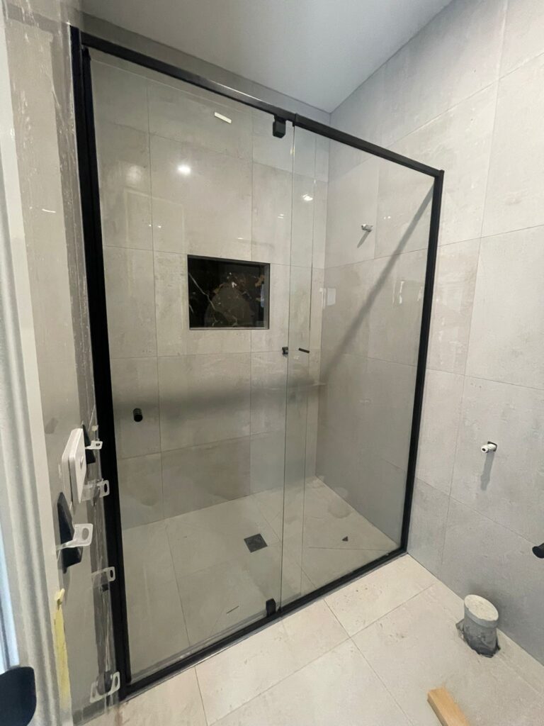 Black frame glass shower enclosure installed in a modern bathroom